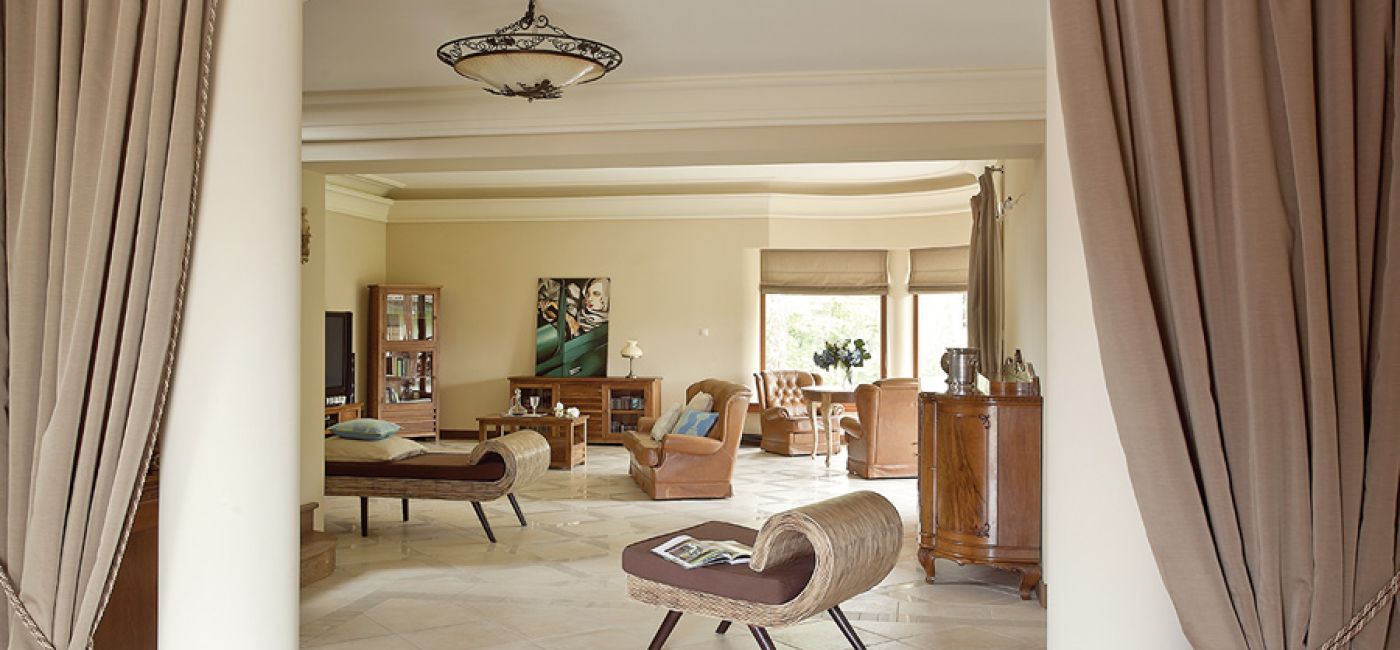 Beże i brązy, solidne dębowe meble i obraz z zabytkowym sportowym samochodem. Klasyka w najlepszym stylu.