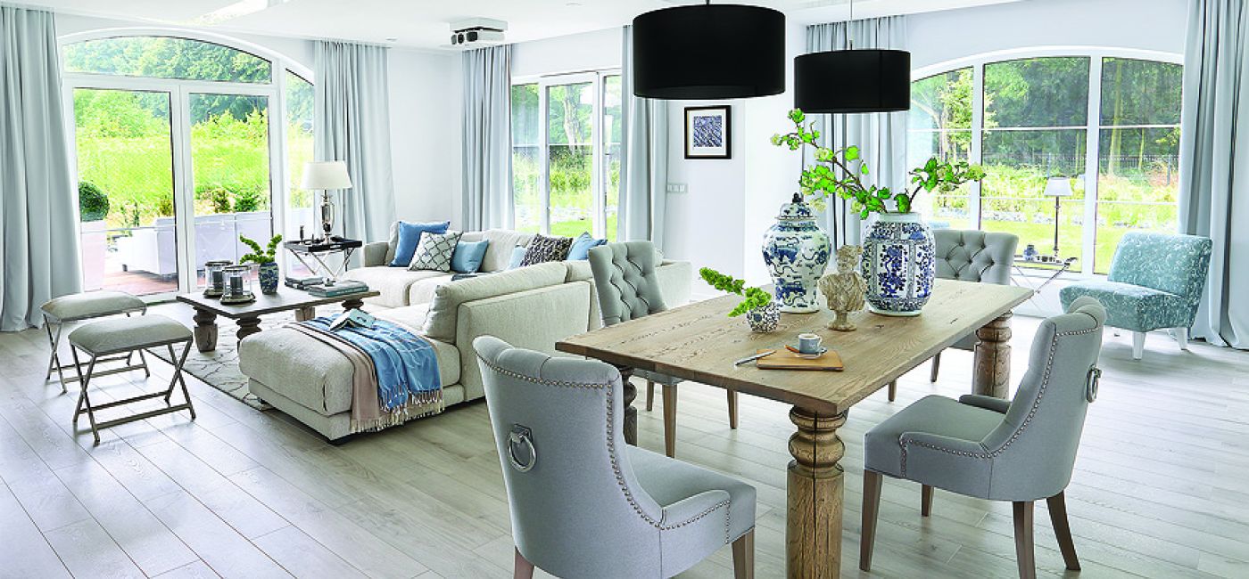 Do dużego masywnego stołu od firmy Jadik pasują fotele ze srebrnymi uchwytami z Decolor i kobaltowe wazony od Casa Mia.