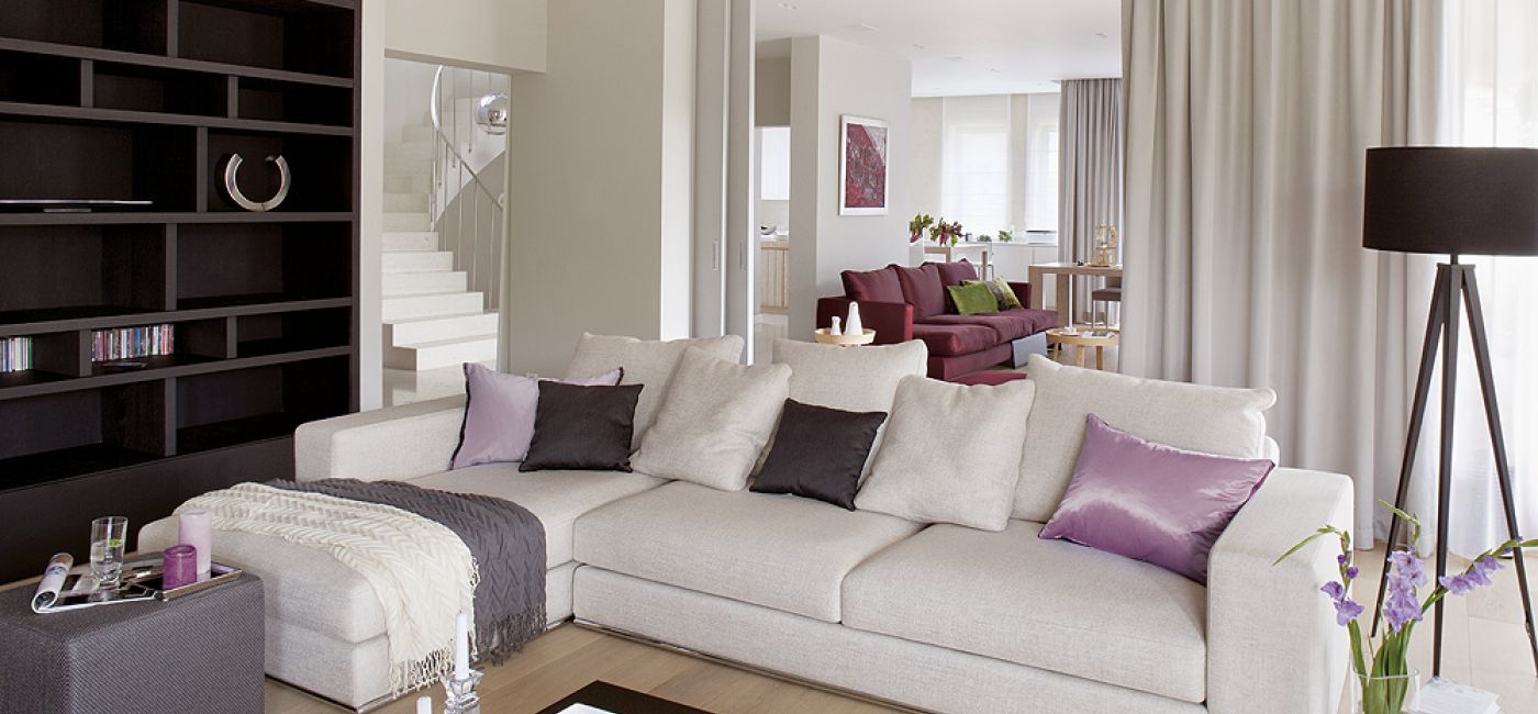 Duży salon można przedzielić drzwiami obitymi tkaniną. Obie kanapy właściciele kupili w Casa Marvell. Stół i stolik kawowy -