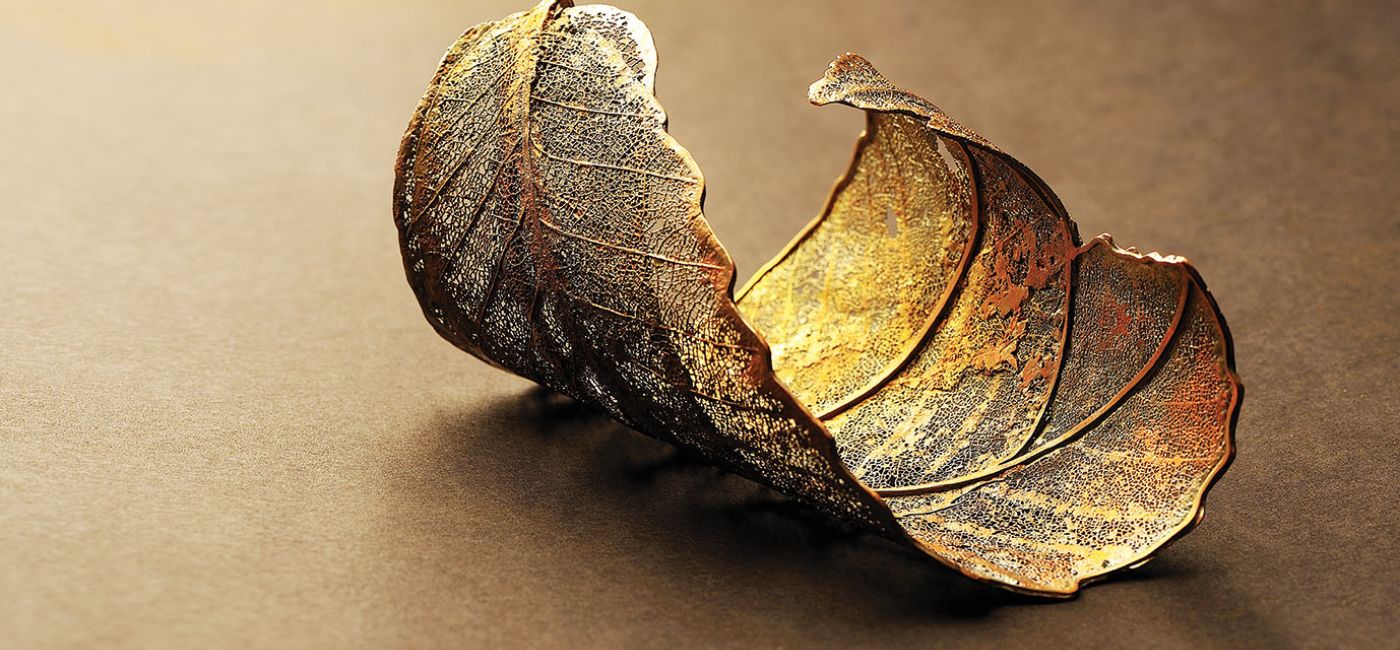 Ewa Rudowska wyczyszczone fragmenty liści pokrywa miedzią, galwanizuje srebrem albo złotem, a potem układa w