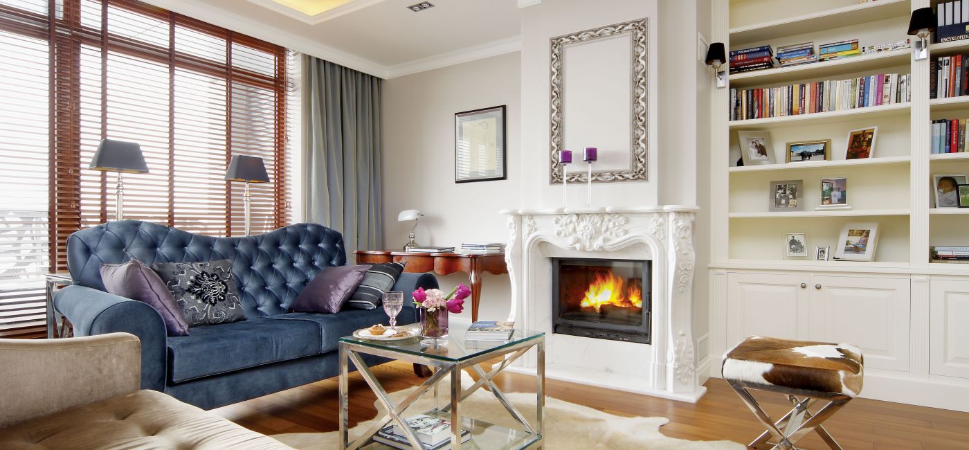 Klasyczny charakter salonu podkreślają marmurowy, rzeźbiony w kwiaty kominek, oraz proste, szerokie sztukaterie.