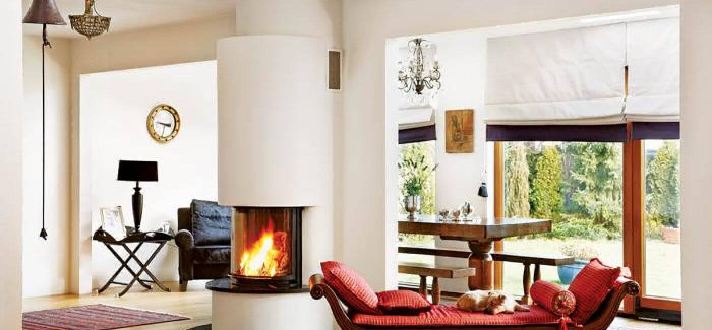 W salonie stoi szezlong z czerwonymi poduszkami.