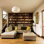 Biblioteka marzeń właścicieli - z przepastnym regałem fornirowanym ciepłym drewnem orzechowym i wygodną kanapą w