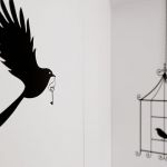 Naklejka z ptaszkiem w klatce zamówiona przez internet i zestawiona z metalowym łańcuszkiem.