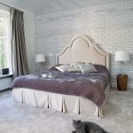 Stylowy mix: pałacowe łóżko, ceglana ściana jak w lofcie i rustykalne stoliki pieńki (z Belbazaar).