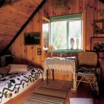 Sypialnia na poddaszu została wyłożona drewnianą boazerią.