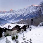 Widok na ośnieżone Alpy. Drewniany dom pod Mont Blanc