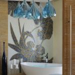 Zestaw siedmiu ręcznie formowanych szklanych kloszy w kształcie kielichów kwiatowych w niewielkim, prostym pokoju kąpielowym.