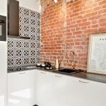 Biel, szmaragd i czerwona cegła w stylowej warszawskiej kawalerce