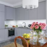 Biała, nowoczesna kuchnia połączona z salonem dodaje wnętrzu lekkości.