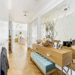 W przedpokoju efektowne lustro z ciętego w romby szkła naklejonego na płytę, ramę zamontowano osobno. Szafkę i puf też