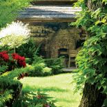 Altana z kamiennym grillem kryta jest podwójnym gontem.