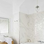 Choć dużo tu bieli, nie jest chłodno i nudno, a to dzięki mozaice nad wanną.