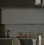 czarna kuchnia z górnymi szarymi szafkami
