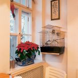 Architektoniczne detale przedwojennego domu podkreślają rustykalny chrakter wnętrza. Biale współczesne krzesła zupełnie przy