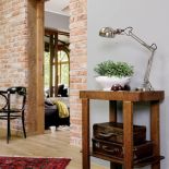 Artdekowski pomocnik, stare walizki i ceglana ściana doskonale wpisują się w klimat loftu.