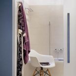 Ascetyczny salon kąpielowy połączony jest z sypialnią szklanymi drzwiami. Zdobi go głównie krysztalowy żyrandol, który