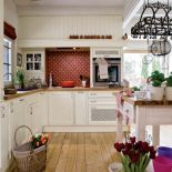 Atmosfera jak w Prowansji: drewno, jasne szafki kuchenne, naturalne światło.