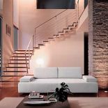 Ażurowe schody zapraszają do wejścia na górę. Ale ich szyki miesza biała kanapa - sprawia, że nie chcemy się