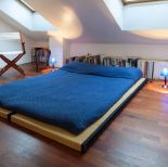 Bambusowy materac i wyrazista pościel - proste, ale wygodne rozwiązanie. Dobre do sypialni na poddaszu