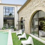 Basen ma 9 metrów, pas trawy, dookoła stoją terakotowe donice z hortensjami i bukszpanem.