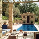 Basen otoczony kamiennym murem. Kamień i drewno w jednym domu