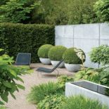 Betonowe mury, donice, oczko wodne - ocieplą je ozdobne trawy i strzyżone bukszpany.