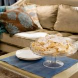 Beżowa kanapa przełamuje dominujące w tym salonie błękity.