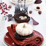 Biała dynia położona na wianku - oryginalna dekoracja stołu