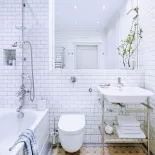 białe płytki na ścianie w łazience