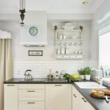 białe szafki z czarnym blatem w kuchni