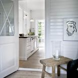 Białe szafki kuchenne doskonale grają z ciepłą, drewnianą podłogą.