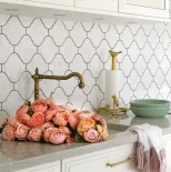 białe płytki między szafkami w kuchni