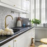 białe szafki kuchenne ze złotymi uchwytami