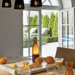 Biało-czarna nowoczesna kuchnia wycisza rozmach reszty domu. Nie brak w niej ciepłuch akcentów: pasiastej tapety