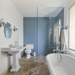 Ciekawy kontrast: dekoracyjne, ręcznie robione płytki podłogowe z ceramiką ścienną ułożoną w cegiełkę.