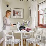 Biały prosty stół i krzesła. Graficzny dom Agaty Budny-Ciszewskiej