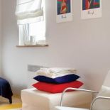 Biały puf i kolorowe poduszki. Urządzony z pomocą... aniołów