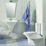 Biel ceramiki podkreślają błękitne kafelki. Umywalka Fontana - 289 zł. Za bidet z tej samej kolekcji zapłacimy 249 zł,