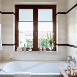 Biel przełamują tu ciemniejsze elementy, np. futryna okna.