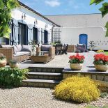 Bielone ściany pawilonu z błękitnymi okiennicami.