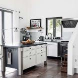 Blaty na szafkach zrobiono ze stali, a ten na wyspie kuchennej – z czarnego betonu.