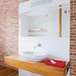 Błyszczący MDF dobrze prezentuje się na tle surowego muru.