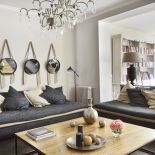 Wokół dużego stołu kawowego dwie sofy marki Zina, inspirowane marokańskimi leżankami. Na ścianach lustra zawieszone