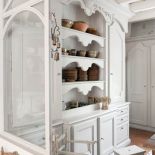 Cenne wazy i naczynia mieszczą się w pojemnym, rzeźbionym kredensie.