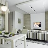 Centralna ściana w salonie wykończona została naturalnym drewnem, które stanowi motyw przewodni całego projektu. Ciekawym