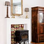 Centralne miejsce w salonie zajmuje kominek i stara szafa.