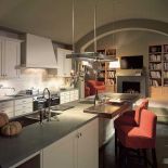 Centralnym punktem w tej kuchni firmy SieMatic jest długa wyspa. Wydzielony blat z ciemnego orzecha to idealne miejsce na