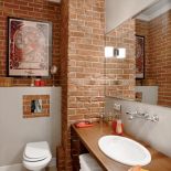 Charakter tej łazience nadaje ceglana ściana.