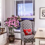 Charakter wnętrzu nadają tkaniny i czerwona poduszka na fotelu.